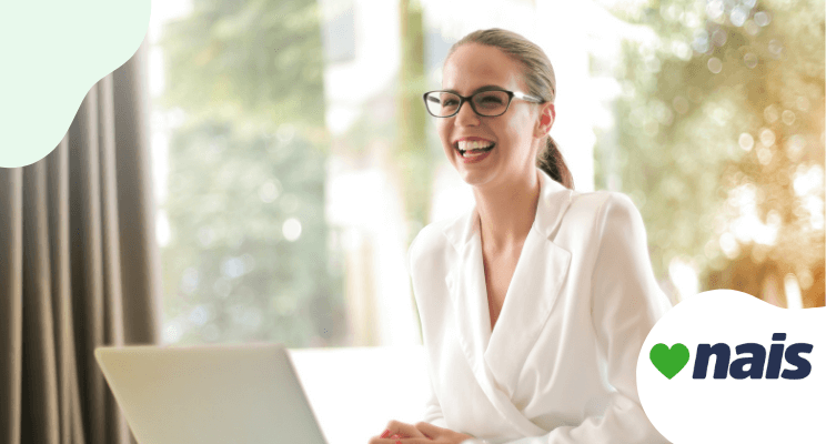woman smiling behind a laptop